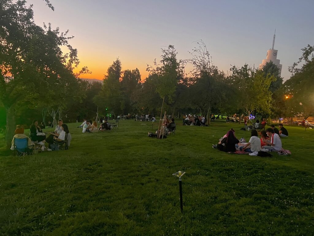 People relaxing on the grass in Seymenler Park at sunset