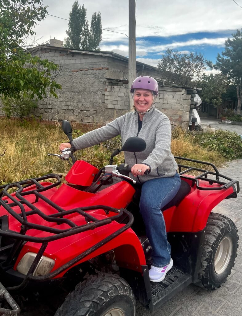 Tiffany smiling on a red ATV before an ATV tour in Cappadocia, Türkiye.