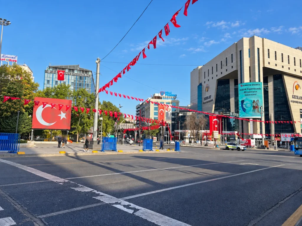 Strings of Turkish flags cross the main street in Kızılay showing the main entrance to Güvenpark.