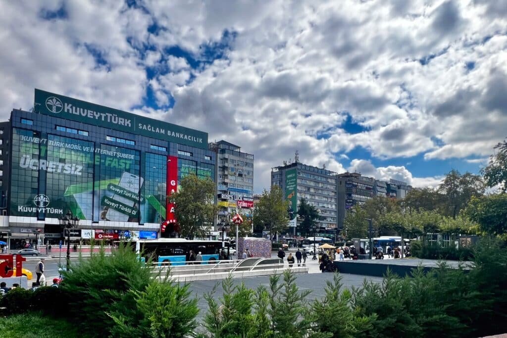 Kızılay city center in Ankara with a Metro entrance, EGO bus, and pedestrians.