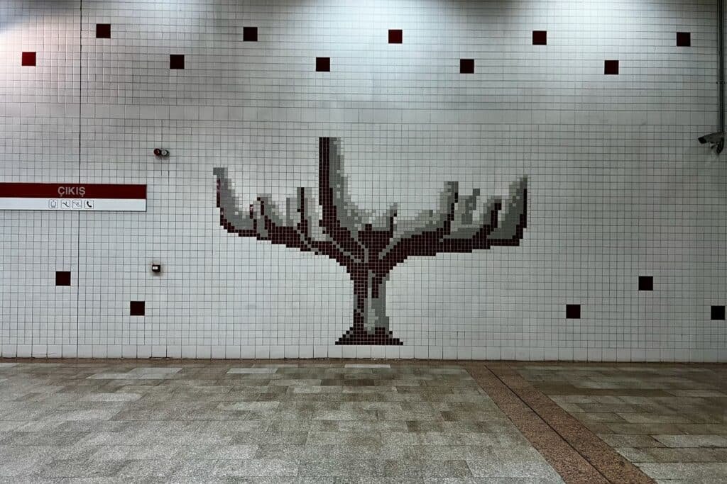 Tree mosaic artwork on a tiled wall inside ODTÜ Metro station in Ankara, Türkiye.