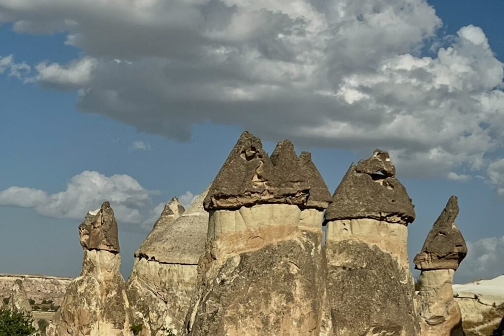 Mushroom-capped fairy chimneys at Paşabağ in Cappadocia beneath a dramatic cloud-filled sky.