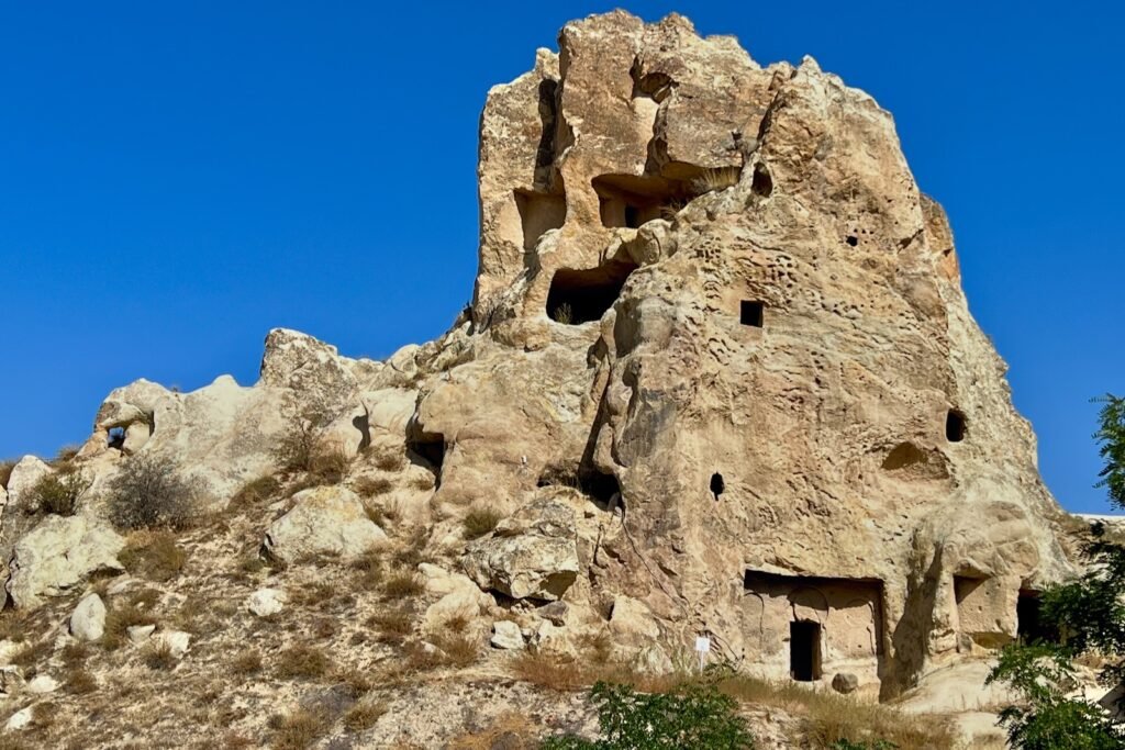 Rahibeler Manastırı, the Nunnery, carved into a tall volcanic rock formation at Göreme Open-Air Museum in Cappadocia, Türkiye