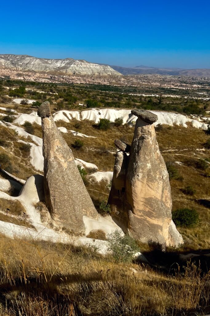 The Three Beauties fairy chimneys, known as Üç Güzeller, rising above the Cappadocia landscape near Ürgüp, Türkiye.